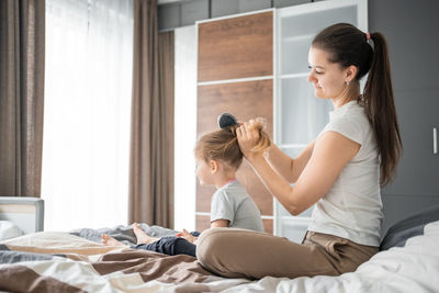 Side view of mother and daughter at home