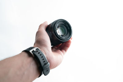 Close-up of hand holding camera against white background