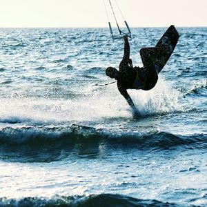 Man windsurfing in sea against sky