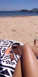 Low section of woman relaxing on beach