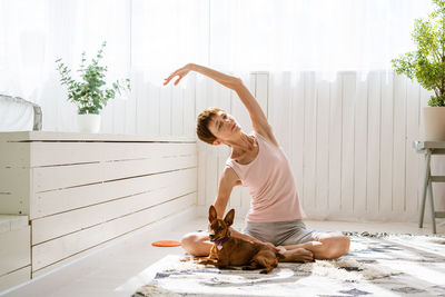 Woman doing yoga with her dog, enjoy and relax with yoga at home, relax