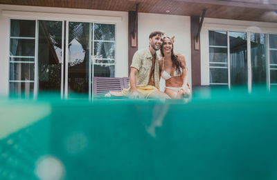 Reflection of couple on window at swimming pool