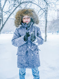 Portrait of young woman standing on snow