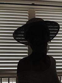 Portrait of woman wearing hat against wall