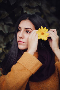 Portrait of young woman holding flower