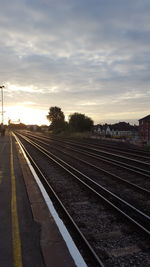 Railroad tracks against sky during sunset