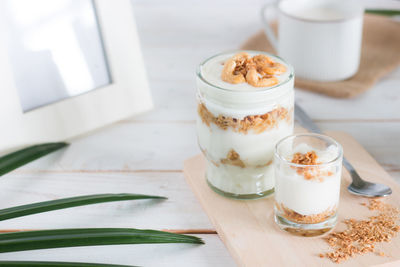 High angle view of dessert in glass by empty picture frame on table