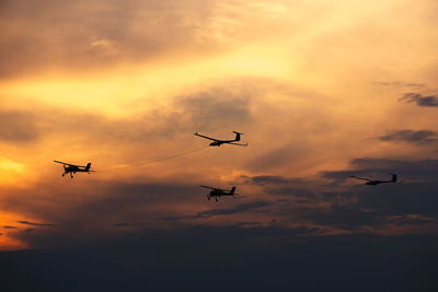 Low angle view of silhouette airplane flying in sky