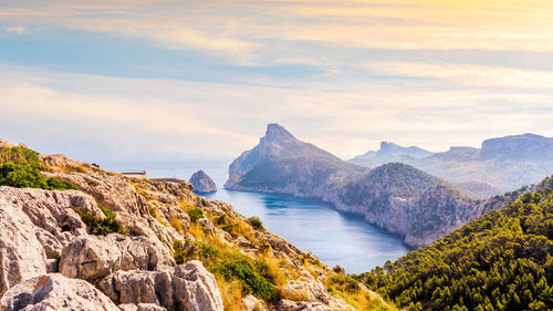 Scenic view of sea and mountains against sky