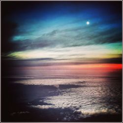 Scenic view of sea against dramatic sky during sunset