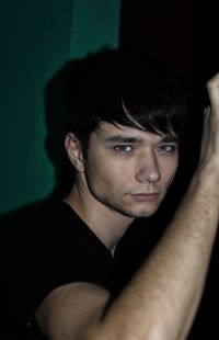 Close-up portrait of young man against black background