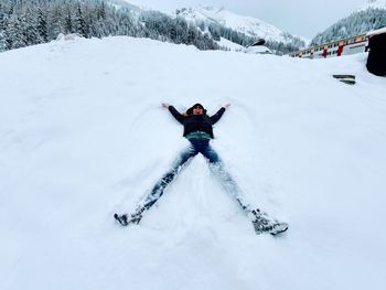 Woman skiing on snow angel  covered field