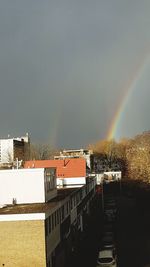 Rainbow over city against clear sky