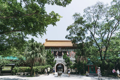 Gazebo in park by building against sky