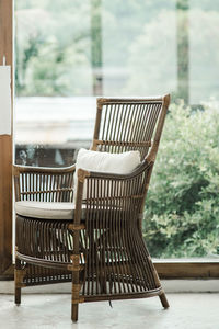 Empty chairs and table against window