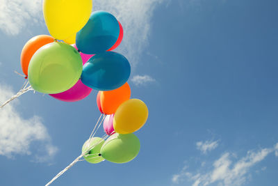 Low angle view of colorful balloons against sky