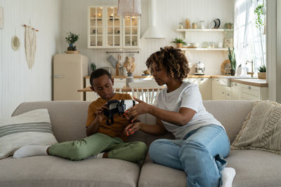 Young woman using mobile phone while sitting at home