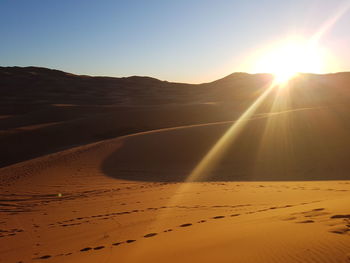 Scenic view of desert against sky during sunset