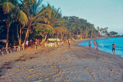 People at beach against sky