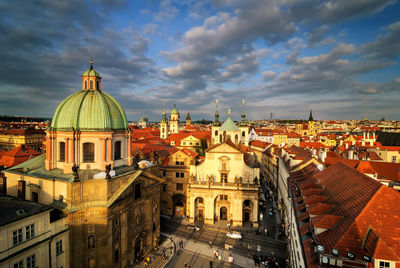 Buildings in city against cloudy sky