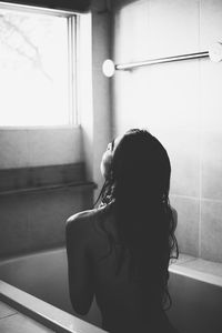Seductive woman sitting in bathtub