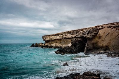 Rock formations by sea against sky