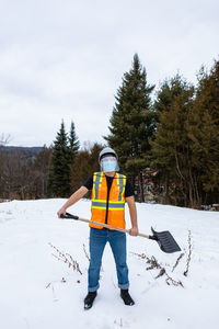 Man standing on snow covered field against sky