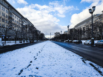 Surface level of snow covered road against sky