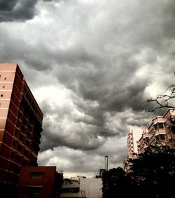 Low angle view of buildings against cloudy sky