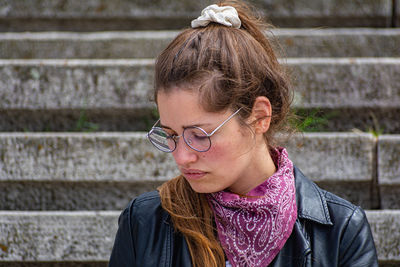 Portrait of young woman standing against wall