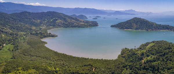 Scenic view of sea and mountains against sky