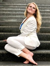 Portrait of beautiful woman sitting on staircase