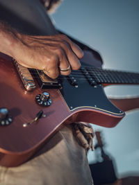 Midsection of man playing guitar