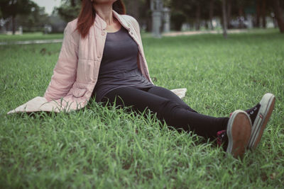 Woman sitting on grass in field