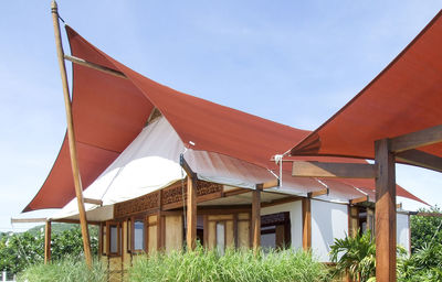 Tent on field by houses against sky