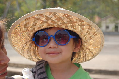 Portrait of boy wearing hat and sunglasses outdoors