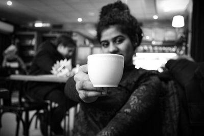 Woman holding coffee cup at restaurant