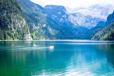 Scenic view of lake and mountains against blue sky