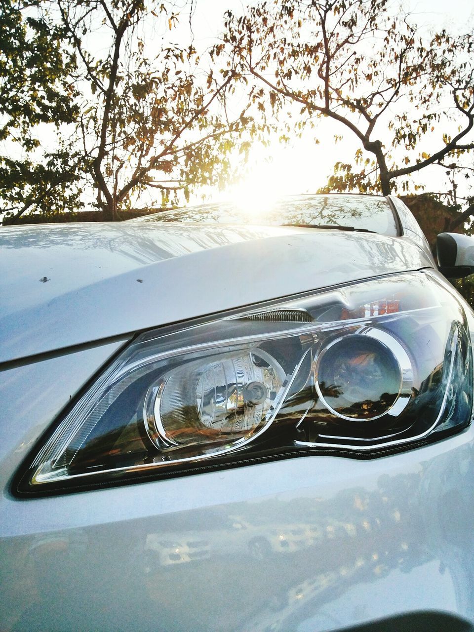 car, land vehicle, sunlight, transportation, sunbeam, mode of transport, sun, tree, snow, cold temperature, winter, day, lens flare, sky, glass - material, built structure, no people, building exterior, architecture, close-up