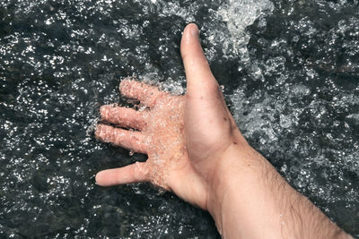 Close-up of hand against water