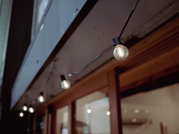 Low angle view of light bulb hanging on ceiling