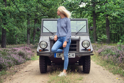 Woman standing on road amidst plants