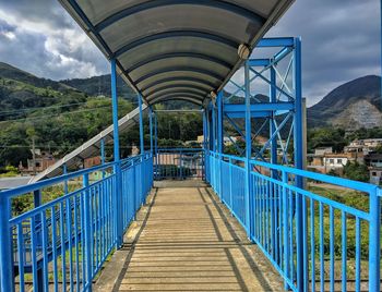 Empty footbridge against sky