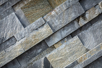 Background of gray and brown stone wall made with blocks . pattern of slate wall texture 