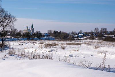 Scenic view of snow covered field against sky