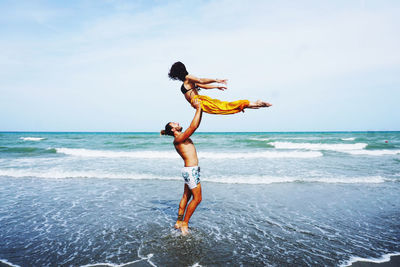 Full length of people at beach against sky