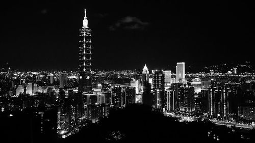 Illuminated cityscape against sky at night