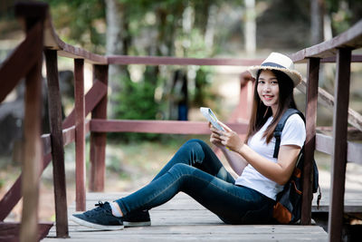 Portrait of woman sitting on railing