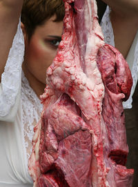 Portrait of young woman in front of raw meat