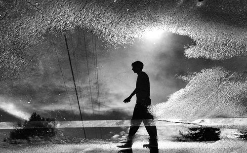 Reflection of people in puddle